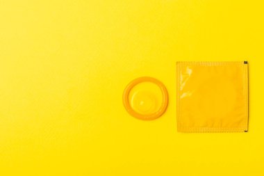 Renkli arka planda prezervatifler. Paketlemede renkli meyve temalı prezervatifler. Güvenli seks konsepti. Doğum kontrol hapı. Farklı doğum kontrol yöntemleri. AİDS önleme. Dünya AIDS Günü. Cinsel sağlık.