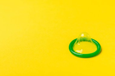 Renkli arka planda prezervatifler. Paketlemede renkli meyve temalı prezervatifler. Güvenli seks konsepti. Doğum kontrol hapı. Farklı doğum kontrol yöntemleri. AİDS önleme. Dünya AIDS Günü. Cinsel sağlık.