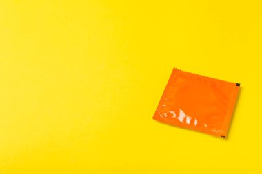 Renkli arka planda prezervatifler. Paketlemede renkli meyve temalı prezervatifler. Güvenli seks konsepti. Doğum kontrol hapı. Farklı doğum kontrol yöntemleri. AİDS önleme. Dünya AIDS Günü. Cinsel sağlık.