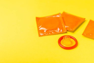 Renkli arka planda prezervatifler. Paketlemede renkli meyve temalı prezervatifler. Güvenli seks konsepti. Doğum kontrol hapı. Farklı doğum kontrol yöntemleri. AİDS önleme. Dünya AIDS Günü. Cinsel sağlık.