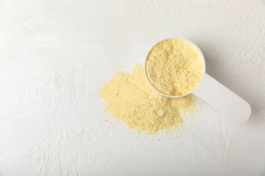 Protein powder. A spoonful of protein powder on a table. Different flavors of whey protein powder. Sports nutrition concept. Gym. Amino acid food supplement, creatine powder. Copy space.