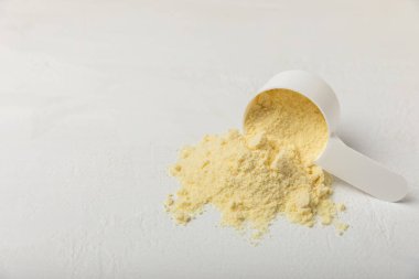 Protein powder. A spoonful of protein powder on a table. Different flavors of whey protein powder. Sports nutrition concept. Gym. Amino acid food supplement, creatine powder. Copy space.