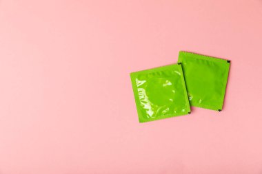 Renkli arka planda prezervatifler. Paketlemede renkli meyve temalı prezervatifler. Güvenli seks konsepti. Doğum kontrol hapı. Farklı doğum kontrol yöntemleri. AİDS önleme. Dünya AIDS Günü. Cinsel sağlık.