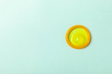 Renkli arka planda prezervatifler. Paketlemede renkli meyve temalı prezervatifler. Güvenli seks konsepti. Doğum kontrol hapı. Farklı doğum kontrol yöntemleri. AİDS önleme. Dünya AIDS Günü. Cinsel sağlık.