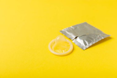 Renkli arka planda prezervatifler. Paketlemede renkli meyve temalı prezervatifler. Güvenli seks konsepti. Doğum kontrol hapı. Farklı doğum kontrol yöntemleri. AİDS önleme. Dünya AIDS Günü. Cinsel sağlık.