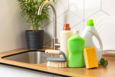 Mutfağın arka planında eko temizlik ürünleri var. Çevre dostu ev temizliği. Bir şişe doğal deterjan yüzeyi, eko fırçalar, süngerler ve paçavralar. Daha temiz bir kavram. Temizlik malzemeleri..