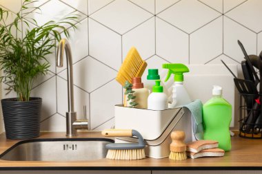 Mutfağın arka planında eko temizlik ürünleri var. Çevre dostu ev temizliği. Bir şişe doğal deterjan yüzeyi, eko fırçalar, süngerler ve paçavralar. Daha temiz bir kavram. Temizlik malzemeleri..