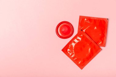 Renkli arka planda prezervatifler. Paketlemede renkli meyve temalı prezervatifler. Güvenli seks konsepti. Doğum kontrol hapı. Farklı doğum kontrol yöntemleri. AİDS önleme. Dünya AIDS Günü. Cinsel sağlık.