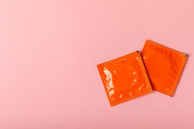 Renkli arka planda prezervatifler. Paketlemede renkli meyve temalı prezervatifler. Güvenli seks konsepti. Doğum kontrol hapı. Farklı doğum kontrol yöntemleri. AİDS önleme. Dünya AIDS Günü. Cinsel sağlık.