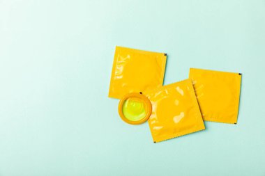 Renkli arka planda prezervatifler. Paketlemede renkli meyve temalı prezervatifler. Güvenli seks konsepti. Doğum kontrol hapı. Farklı doğum kontrol yöntemleri. AİDS önleme. Dünya AIDS Günü. Cinsel sağlık.