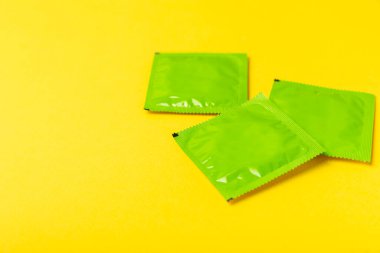 Renkli arka planda prezervatifler. Paketlemede renkli meyve temalı prezervatifler. Güvenli seks konsepti. Doğum kontrol hapı. Farklı doğum kontrol yöntemleri. AİDS önleme. Dünya AIDS Günü. Cinsel sağlık.