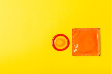 Renkli arka planda prezervatifler. Paketlemede renkli meyve temalı prezervatifler. Güvenli seks konsepti. Doğum kontrol hapı. Farklı doğum kontrol yöntemleri. AİDS önleme. Dünya AIDS Günü. Cinsel sağlık.