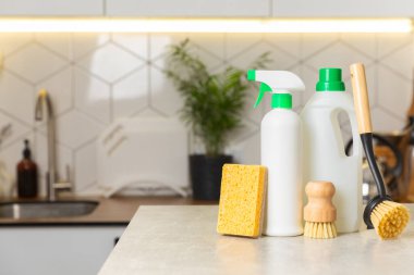 Mutfağın arka planında eko temizlik ürünleri var. Çevre dostu ev temizliği. Bir şişe doğal deterjan yüzeyi, eko fırçalar, süngerler ve paçavralar. Daha temiz bir kavram. Temizlik malzemeleri..