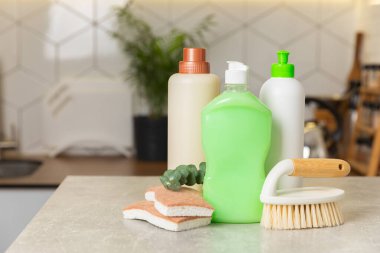 Mutfağın arka planında eko temizlik ürünleri var. Çevre dostu ev temizliği. Bir şişe doğal deterjan yüzeyi, eko fırçalar, süngerler ve paçavralar. Daha temiz bir kavram. Temizlik malzemeleri..