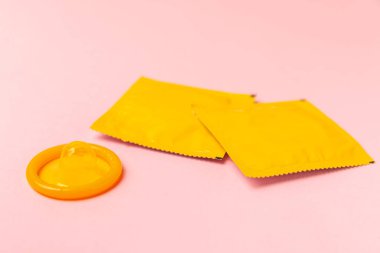 Renkli arka planda prezervatifler. Paketlemede renkli meyve temalı prezervatifler. Güvenli seks konsepti. Doğum kontrol hapı. Farklı doğum kontrol yöntemleri. AİDS önleme. Dünya AIDS Günü. Cinsel sağlık.