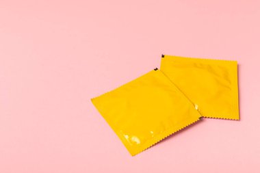 Renkli arka planda prezervatifler. Paketlemede renkli meyve temalı prezervatifler. Güvenli seks konsepti. Doğum kontrol hapı. Farklı doğum kontrol yöntemleri. AİDS önleme. Dünya AIDS Günü. Cinsel sağlık.