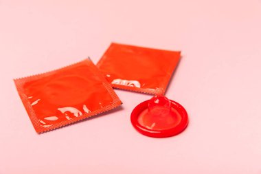 Renkli arka planda prezervatifler. Paketlemede renkli meyve temalı prezervatifler. Güvenli seks konsepti. Doğum kontrol hapı. Farklı doğum kontrol yöntemleri. AİDS önleme. Dünya AIDS Günü. Cinsel sağlık.