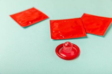 Renkli arka planda prezervatifler. Paketlemede renkli meyve temalı prezervatifler. Güvenli seks konsepti. Doğum kontrol hapı. Farklı doğum kontrol yöntemleri. AİDS önleme. Dünya AIDS Günü. Cinsel sağlık.