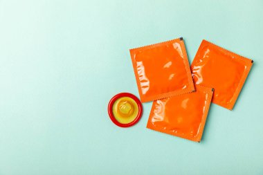 Renkli arka planda prezervatifler. Paketlemede renkli meyve temalı prezervatifler. Güvenli seks konsepti. Doğum kontrol hapı. Farklı doğum kontrol yöntemleri. AİDS önleme. Dünya AIDS Günü. Cinsel sağlık.