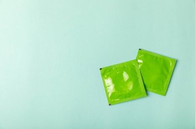 Renkli arka planda prezervatifler. Paketlemede renkli meyve temalı prezervatifler. Güvenli seks konsepti. Doğum kontrol hapı. Farklı doğum kontrol yöntemleri. AİDS önleme. Dünya AIDS Günü. Cinsel sağlık.