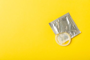 Renkli arka planda prezervatifler. Paketlemede renkli meyve temalı prezervatifler. Güvenli seks konsepti. Doğum kontrol hapı. Farklı doğum kontrol yöntemleri. AİDS önleme. Dünya AIDS Günü. Cinsel sağlık.