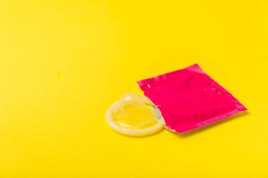 Renkli arka planda prezervatifler. Paketlemede renkli meyve temalı prezervatifler. Güvenli seks konsepti. Doğum kontrol hapı. Farklı doğum kontrol yöntemleri. AİDS önleme. Dünya AIDS Günü. Cinsel sağlık.