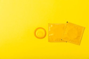 Renkli arka planda prezervatifler. Paketlemede renkli meyve temalı prezervatifler. Güvenli seks konsepti. Doğum kontrol hapı. Farklı doğum kontrol yöntemleri. AİDS önleme. Dünya AIDS Günü. Cinsel sağlık.