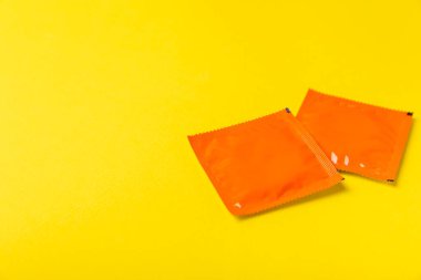 Renkli arka planda prezervatifler. Paketlemede renkli meyve temalı prezervatifler. Güvenli seks konsepti. Doğum kontrol hapı. Farklı doğum kontrol yöntemleri. AİDS önleme. Dünya AIDS Günü. Cinsel sağlık.