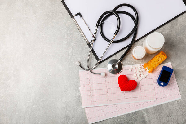 Медицинский стетоскоп, красное сердце и кардиограмма на цветном фоне. ЭКГ, сердечный приступ, сердечный приступ, кардиограмма. Следы пульса кардиограммы и концепция сердца. Healthcare.Space для текста