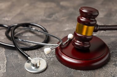 Masaya steteskop ve çekiç. Tıbbi hata, kişisel yaralanma avukatı, ve sağlık hizmeti hukuki açıdan. Avukat. Tıbbi ihmalin hukuki tanımı. Hukuk kavramı. Sağlık ve Tıp.