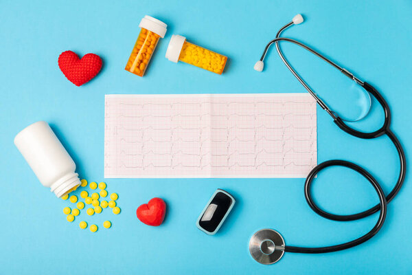 Медицинский стетоскоп, красное сердце и кардиограмма на цветном фоне. ЭКГ, сердечный приступ, сердечный приступ, кардиограмма. Следы пульса кардиограммы и концепция сердца. Healthcare.Space для текста