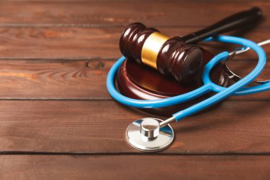 Masaya steteskop ve çekiç. Tıbbi hata, kişisel yaralanma avukatı, ve sağlık hizmeti hukuki açıdan. Avukat. Tıbbi ihmalin hukuki tanımı. Hukuk kavramı. Sağlık ve Tıp.