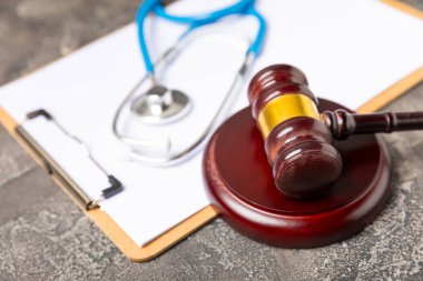 Masaya steteskop ve çekiç. Tıbbi hata, kişisel yaralanma avukatı, ve sağlık hizmeti hukuki açıdan. Avukat. Tıbbi ihmalin hukuki tanımı. Hukuk kavramı. Sağlık ve Tıp.