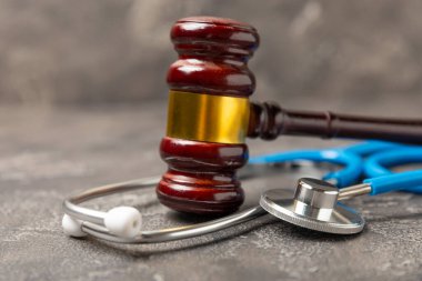 Masaya steteskop ve çekiç. Tıbbi hata, kişisel yaralanma avukatı, ve sağlık hizmeti hukuki açıdan. Avukat. Tıbbi ihmalin hukuki tanımı. Hukuk kavramı. Sağlık ve Tıp.