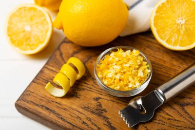 Limon aromalı. Taze sarı organik limonlar ve ahşap bir masada rende. Citrus lezzet rendesi. Limon kabuğu. Mesaj için C vitamini. Boşluğu kopyala.