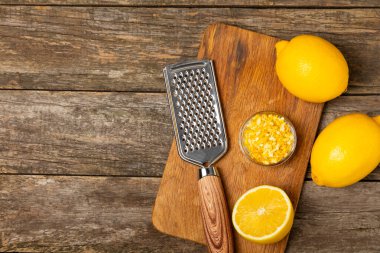 Limon aromalı. Taze sarı organik limonlar ve ahşap bir masada rende. Citrus lezzet rendesi. Limon kabuğu. Mesaj için C vitamini. Boşluğu kopyala.