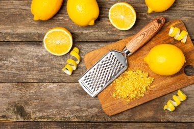 Limon aromalı. Taze sarı organik limonlar ve ahşap bir masada rende. Citrus lezzet rendesi. Limon kabuğu. Mesaj için C vitamini. Boşluğu kopyala.