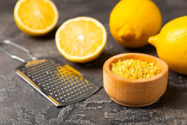 Limon aromalı. Taze sarı organik limonlar ve ahşap bir masada rende. Citrus lezzet rendesi. Limon kabuğu. Mesaj için C vitamini. Boşluğu kopyala.