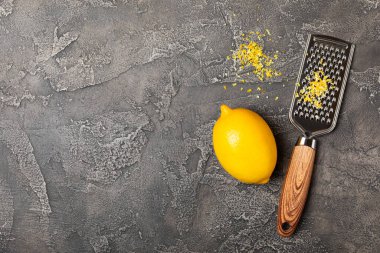 Limon aromalı. Taze sarı organik limonlar ve ahşap bir masada rende. Citrus lezzet rendesi. Limon kabuğu. Mesaj için C vitamini. Boşluğu kopyala.