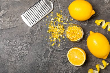 Limon aromalı. Taze sarı organik limonlar ve ahşap bir masada rende. Citrus lezzet rendesi. Limon kabuğu. Mesaj için C vitamini. Boşluğu kopyala.