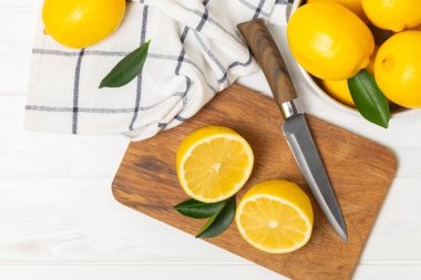 Tahta bir masada limon. Bir dilim taze limon. Turunçgil yapraklı taze limon. Limon suyu. Yemek ve içecek malzemeleri hazırlanıyor. Sağlıklı beslenme. Metin için C vitamini alanı.