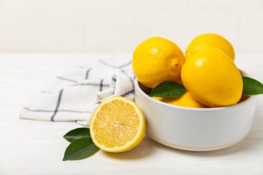 Tahta bir masada limon. Bir dilim taze limon. Turunçgil yapraklı taze limon. Limon suyu. Yemek ve içecek malzemeleri hazırlanıyor. Sağlıklı beslenme. Metin için C vitamini alanı.