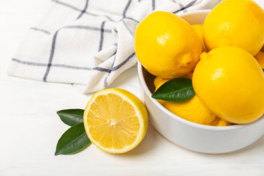 Tahta bir masada limon. Bir dilim taze limon. Turunçgil yapraklı taze limon. Limon suyu. Yemek ve içecek malzemeleri hazırlanıyor. Sağlıklı beslenme. Metin için C vitamini alanı.