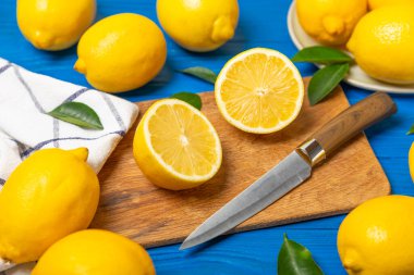 Tahta bir masada limon. Bir dilim taze limon. Turunçgil yapraklı taze limon. Limon suyu. Yemek ve içecek malzemeleri hazırlanıyor. Sağlıklı beslenme. Metin için C vitamini alanı.