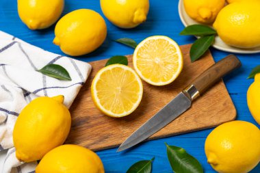 Tahta bir masada limon. Bir dilim taze limon. Turunçgil yapraklı taze limon. Limon suyu. Yemek ve içecek malzemeleri hazırlanıyor. Sağlıklı beslenme. Metin için C vitamini alanı.