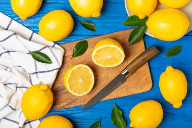 Tahta bir masada limon. Bir dilim taze limon. Turunçgil yapraklı taze limon. Limon suyu. Yemek ve içecek malzemeleri hazırlanıyor. Sağlıklı beslenme. Metin için C vitamini alanı.