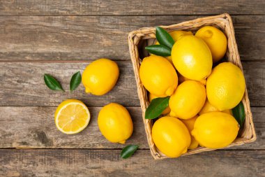 Tahta bir masada limon. Bir dilim taze limon. Turunçgil yapraklı taze limon. Limon suyu. Yemek ve içecek malzemeleri hazırlanıyor. Sağlıklı beslenme. Metin için C vitamini alanı.