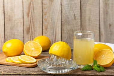 Limon suyu. Kasede taze limon suyu. Olgun narenciye, nane, meyve suyu ve masada meyve sıkacağı. C vitamini. Limon suyu. Pişirme ya da salata sosu için. Mesaj için yer var. Boşluğu kopyala.