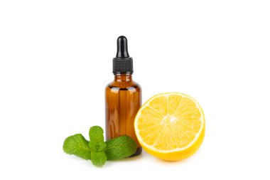 Limon dilimlenmiş limonlu bir şişede limon yağı ve beyaz arka planda izole edilmiş yapraklar. Limon yağı. Aromatik esanslı parfüm şişesi. Serum, limon özü. C vitamini. Doğal kozmetik ürünler. Aromaterapi. Spa mı? Metin için boşluk.