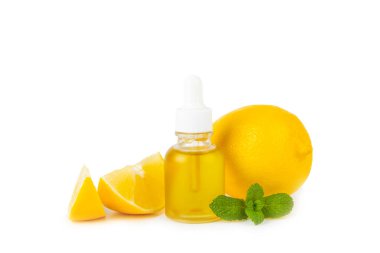 Limon dilimlenmiş limonlu bir şişede limon yağı ve beyaz arka planda izole edilmiş yapraklar. Limon yağı. Aromatik esanslı parfüm şişesi. Serum, limon özü. C vitamini. Doğal kozmetik ürünler. Aromaterapi. Spa mı? Metin için boşluk.